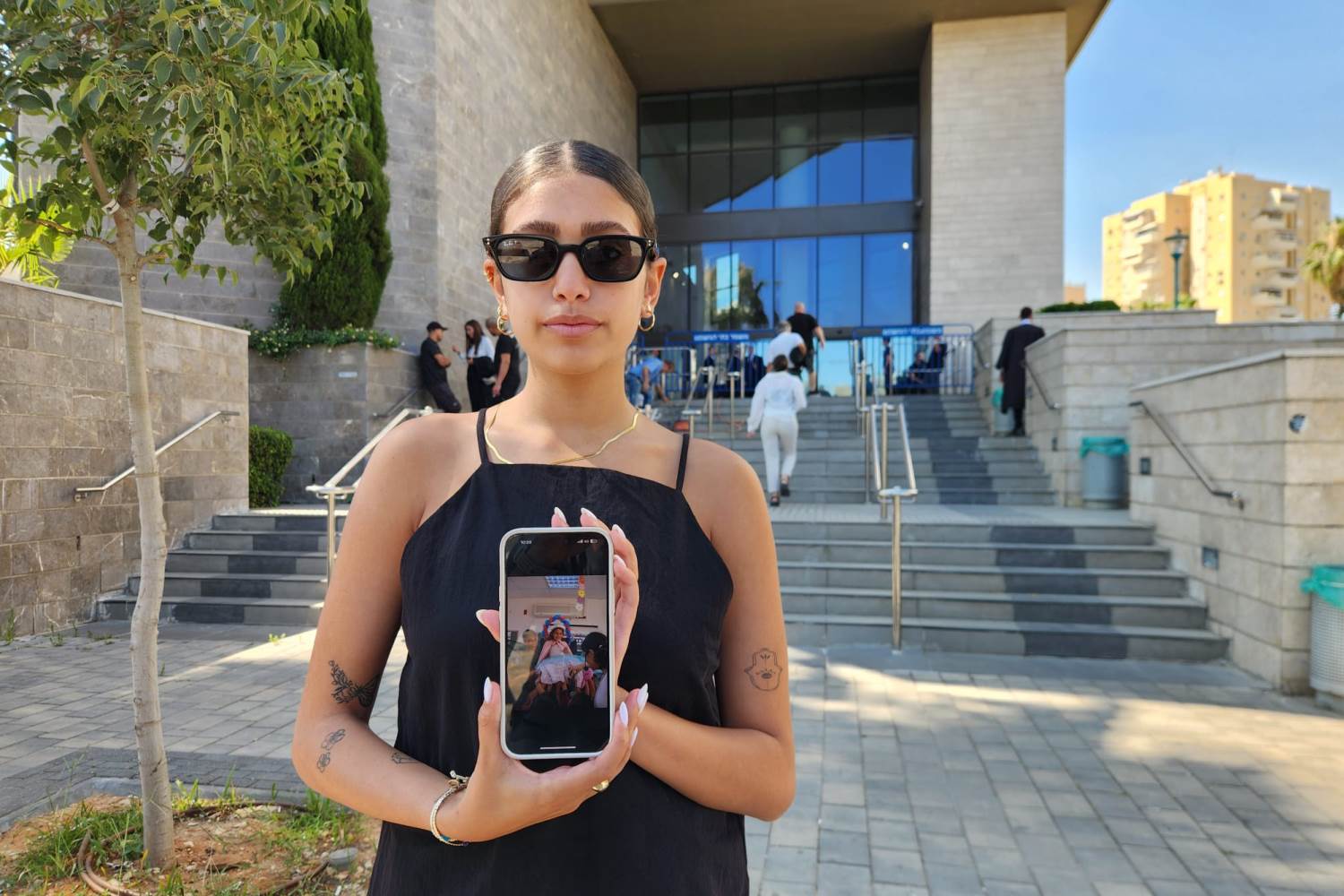 ליאן, ביתו הבכורה של אייל יהודה ז"ל, בפתח בית המשפט עם תמונת אביה